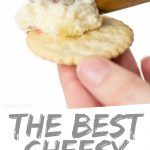 PINTEREST IMAGE with words "The Best Cheesy Horseradish Cracker Dip" Cheesy Horseradish Cracker Dip being spread on a cracker
